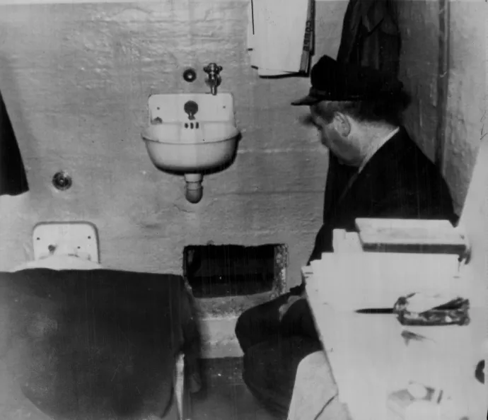 Egy börtönőr térdel a Frank Morris cellájában lévő, a szökéshez használt lyuk mellett – Fotó: Denver Post / Getty Images