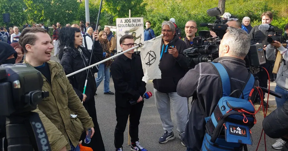 Videón, ahogy a Szuverenitásvédelmi Hivatalnál tüntetők veszik körbe a Hír TV stábját