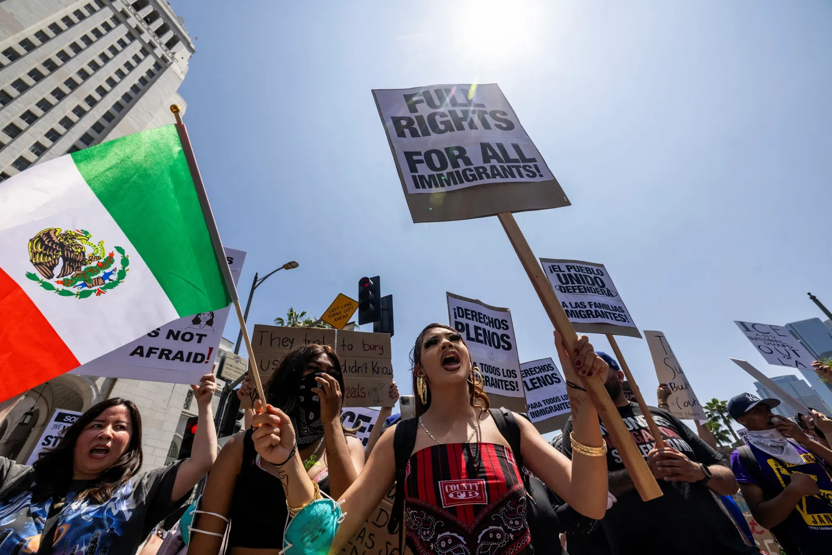 Transzparensekkel felszerelkezett tüntetők Los Angeles belvárosában, a városháza épülete előtt 2025. június 8-án – Fotó: Barbara Davidson / Reuters