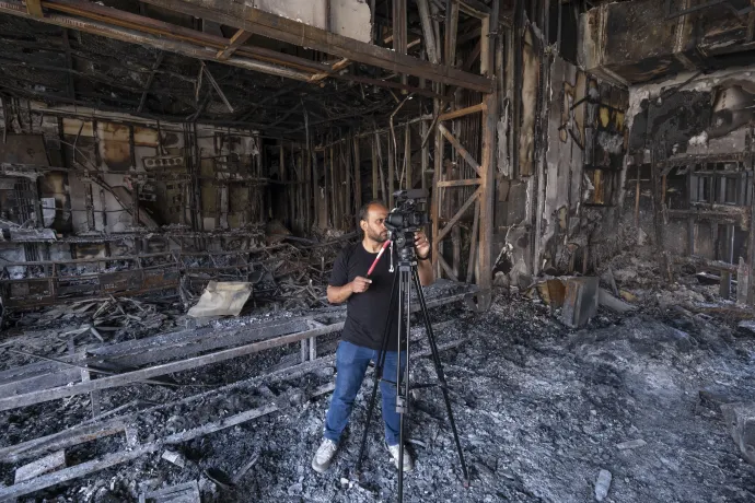 Iráni operatőr videókat készít 2025. június 19-én az iráni állami televízió teheráni épületében, amely az izraeli csapásokban megsemmisült – Fotó: Morteza Nikoubazl / NurPhoto / AFP