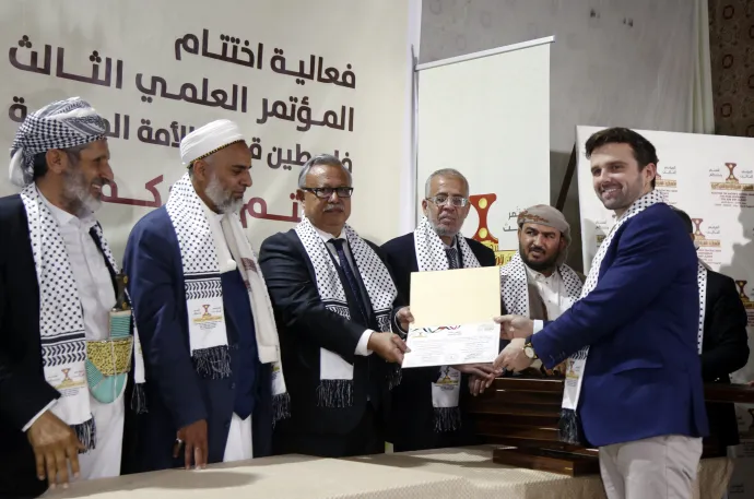 Jackson Hinkle oklevelet vesz át jemeni tisztviselőktől egy Palesztináról tartott konferencián Jemen fővárosában, Szanaában 2025 márciusában – Fotó: Mohammed Hamoud / Getty Images
