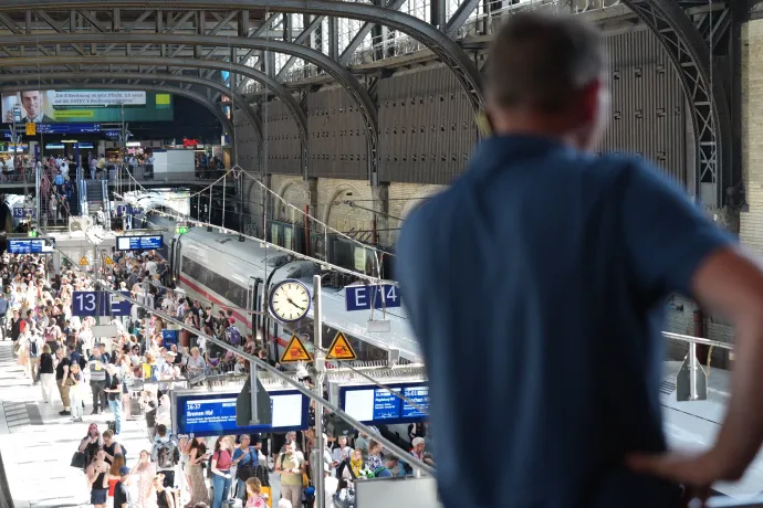Utasok várakoznak a hamburgi főpályaudvaron 2025. július 1-én, egy tűzszerészeti akció, valamint a hőség miatti tüzek miatt a nap végén szünetelt a vonatforgalom Észak-Németországban – Fotó: Marcus Brandt / dpa Picture-Alliance / AFP