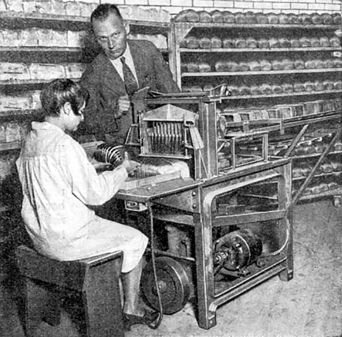 1930-as fénykép a Popular Science magazinból: „Óránként ezer szelet kenyér”. A Frederick Rohwedder által feltalált szeletelőgép munka közben egy St. Louis-i pékségben – Fotó: Popular Science / Wikipedia 