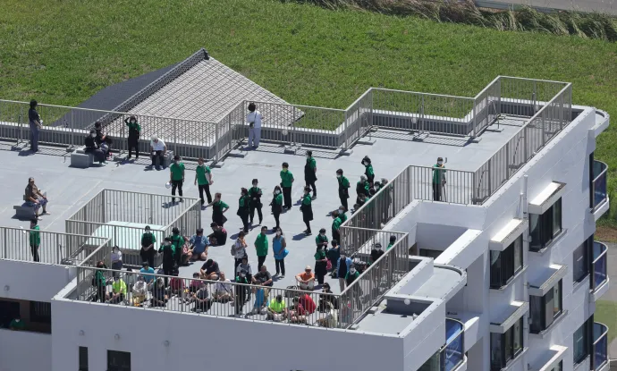 A cunamiriadó miatt tetőre menekült emberek Oamisiraszato városban, Csiba prefektúrában – Fotó: Toshiyuki Kon / The Yomiuri Shimbun / AFP