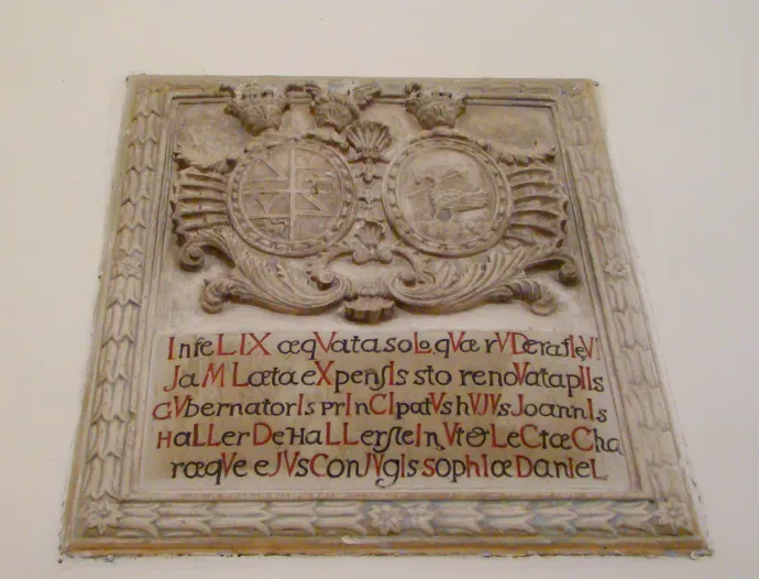 A Haller család címere a templomfalon, a kolostorkert kapuja – Fotók: Wikipédia