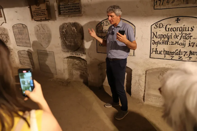 Kovács Zsolt magyaráz a kriptában, illetve Apor István síremléke – Fotó: Gál László / Transtelex