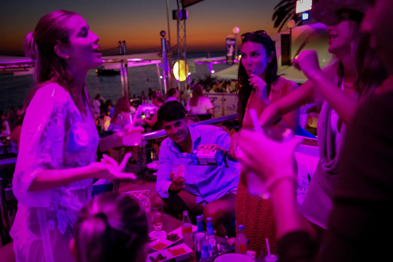 Bulizók táncolnak a híres Cafe del Marban, a sziget 1980-ban alapított klubjában Sant Antoni de Portmanyban / A 32 éves Saray Benito adja elő tűzzsonglőr számát a Cafe del Marban – Fotó: Nacho Doce / Reuters