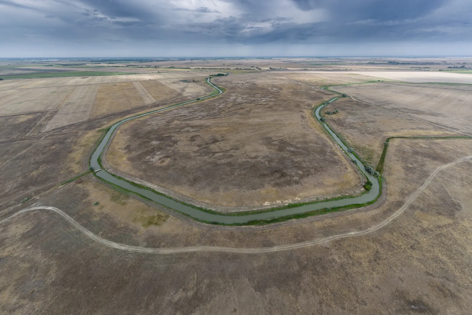 Víz a Kórógy-érben, Fábiánsebestyén határában, 2025. augusztus elején. A csatornák feltöltése nem elégséges megoldás, árasztás nélkül a víznek nincs különösebb hatása a kiszáradt tájra és az elsivatagosodást sem állítja meg. Ez legfeljebb az öntözést végző gazdáknak és a vízimadaraknak segítség