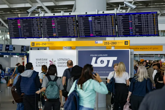 Utasok figyelik az információs táblát a varsói nemzetközi repülőtéren 2025. szeptember 10-én – Fotó: Wojtek Radwanski / AFP