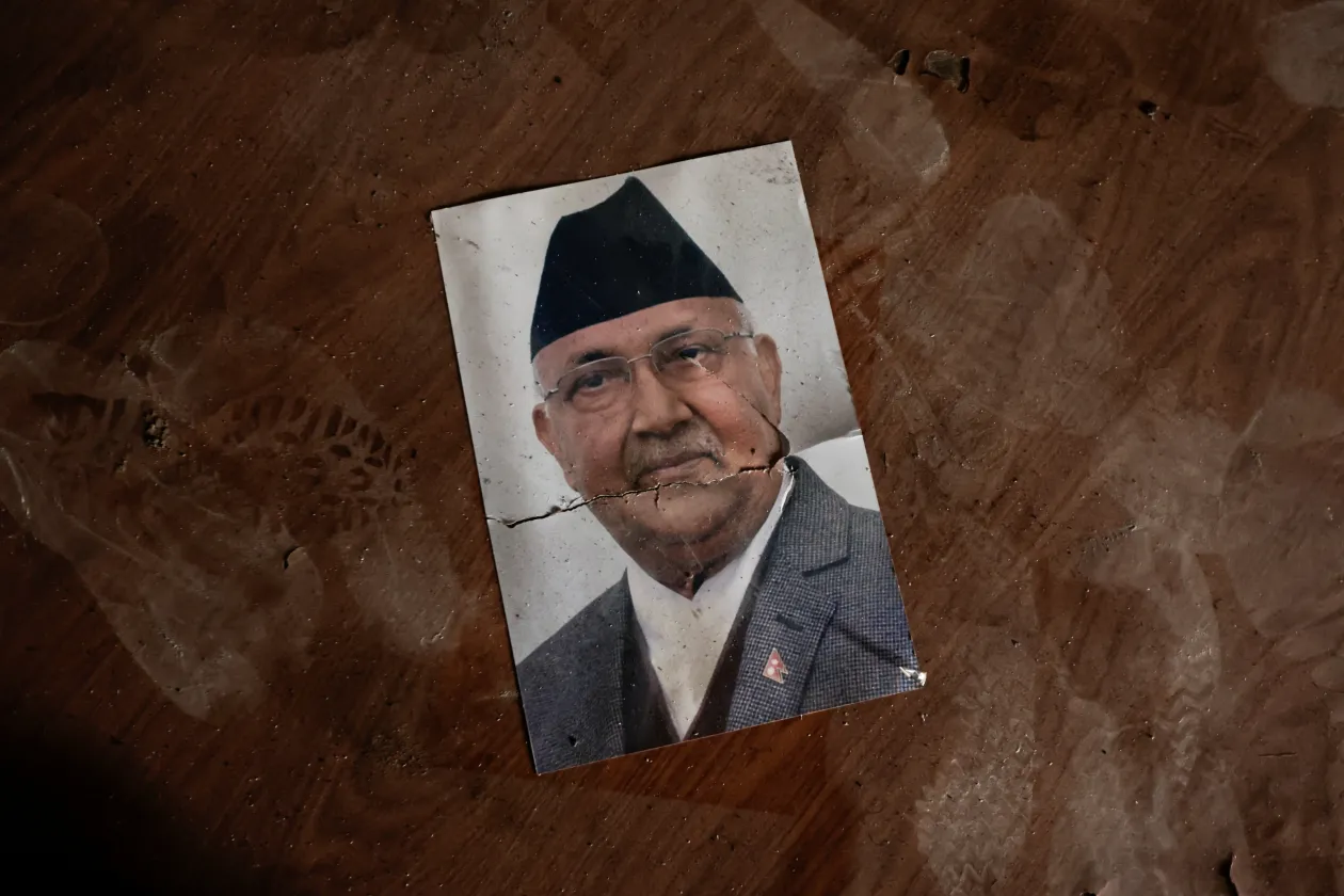 Balra, a miniszterelnök irodájának, és több minisztériumnak otthont adó kormányzati épület leégett romjai, 2025. szeptember 11-én. Jobbra KP Sharma Oli lemondott kormányfő fényképe az épület padlóján. Fotó: Navesh Chitrakar / Reuters