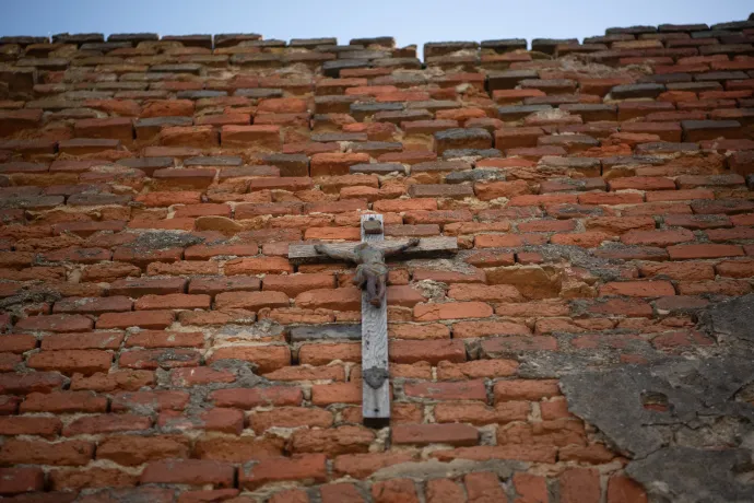 Kövér Márton által a régi templom falára kitett feszület és a jóvátételként épített új templom Folyáson – Fotó: Bődey János / Telex
