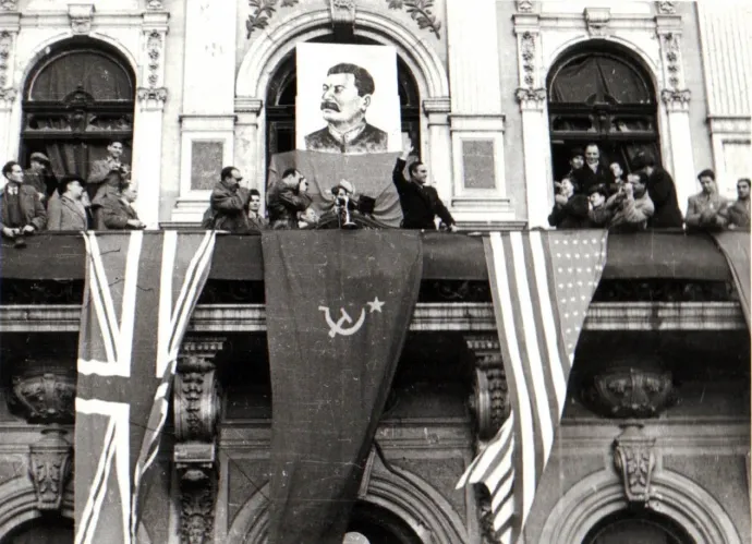 Gheorghe Gheorghiu-Dej a fővárosi dolgozók nagygyűlésének elnökségében 1944. november 7-én, a bolsevik forradalom évfordulója alkalmából rendezett ünnepségen. A beszédek a Sturza-palota erkélyéről hangzottak el, a Győzelem téren – Fotó: IICMER