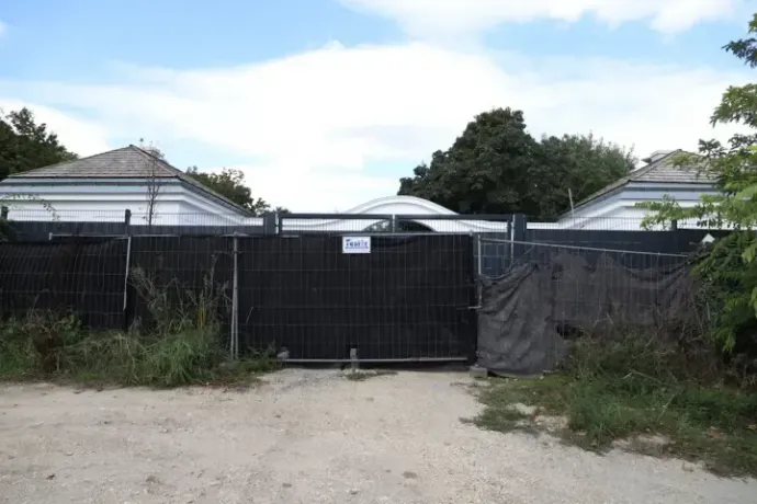 A fence and tarpaulin cover one of the entrances to the estate in Hatvanpuszta. Photo: Direkt36
