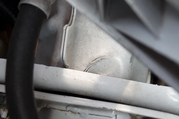 A zárhíd műanyag takarója is repedt, és ütésre utaló gyűrődés is látszik a hossztartón a motortérben – Fotó: Rusznák András / Gor-Car