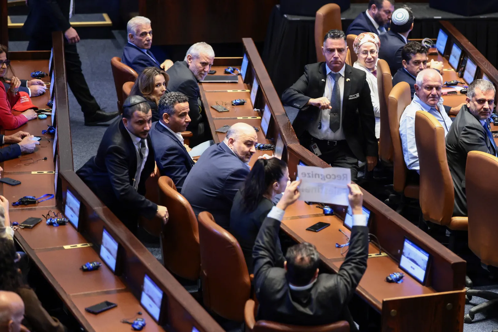 Ajman Odeh, a kneszet tagja, akit a felirat magasba emelése miatt kivezettek a teremből Donald Trump 2025. október 13-i beszéde alatt – Fotó: Evelyn Hockstein / Pool / Reuters