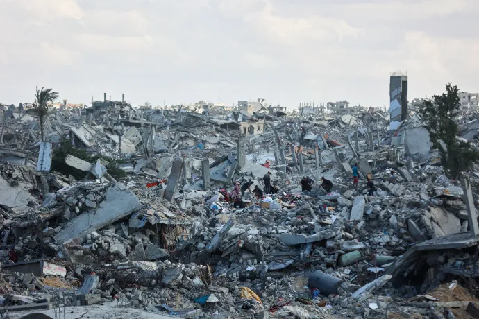 Palesztinok kutatják át egy lebombázott épület romjait a Gázai övezet déli részén fekvő Hán Júniszban 2025. október 12-én – Fotó: Omar Al-Qattaa / AFP or licensors