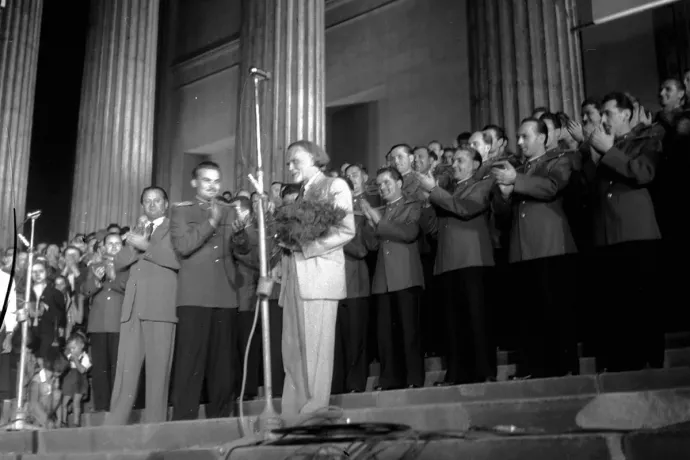 Kodály Zoltánt tapsolják 1956. szeptember 6-án a Nemzeti Múzeum lépcsőjén, a Honvéd Férfikar koncertje után. Kodály mellett balra egyenruhában Vass Lajos őrnagy, az együttes karnagya, mellette Ortutay Gyula néprajzkutató, a Hazafias Népfront elnöke. Az együttes másnap indult a három hónapos kínai turnéra – Fotó: Honvéd Együttes archívuma