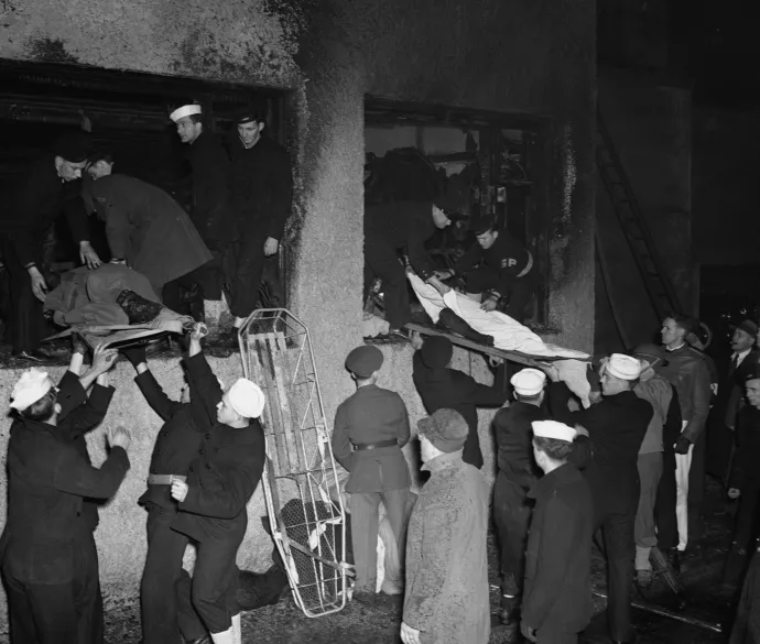 Katonák és tengerészek hordágyakon adják ki az áldozatokat és a sérülteket a kiégett klub ablakán – Fotó: Bettmann / Getty Images