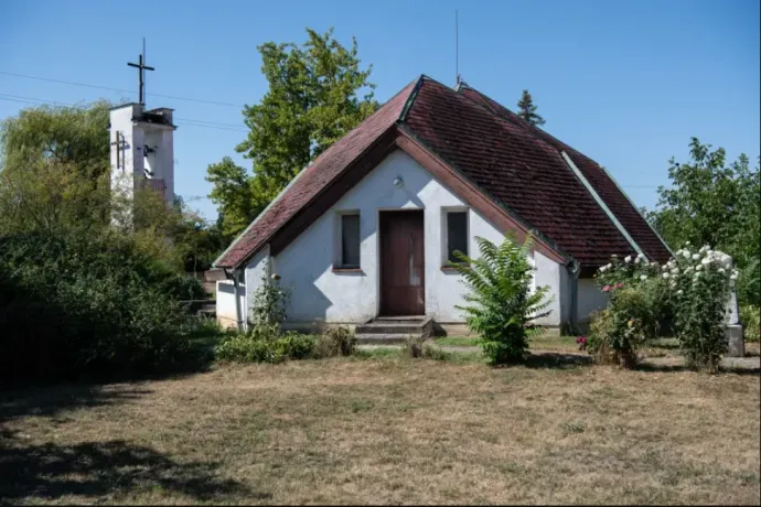 The crucifix placed on the wall of the old church by Márton Kövér and the new church built in Folyás as reparation – Photo: János Bődey / Telex