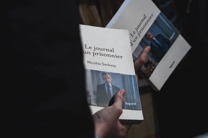 Sarkozy könyve a dedikálásra sorban állók kezében – Fotó: Carine Schmitt / Hans Lucas / AFP