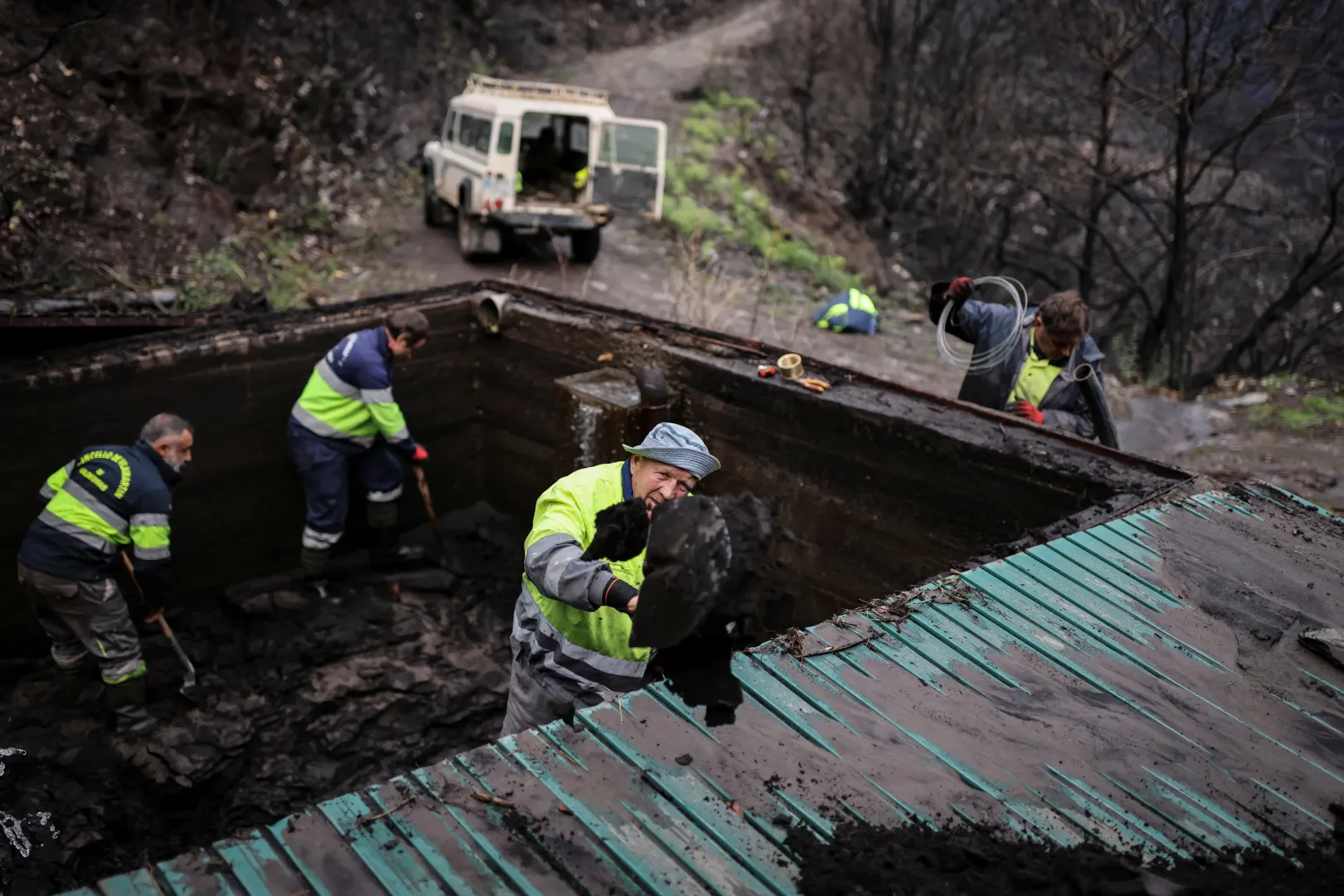A helyiek eltakarítják a hamut és a sarat Vilamartín de Valdeorras településen 2025. november 7-én – Fotó: Nacho Doce / Reuters