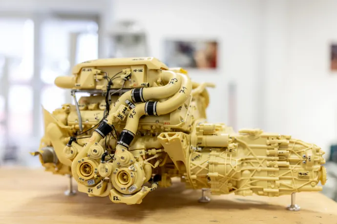 Az egyes makettmotorok összeszerelését számozott próbapéldányok segítik. A fenti képen egy Bugatti Chiron W16-os, négy turbófeltöltővel szerelt motorjának kicsinyített mása látható. A Le Mans-i versenyautók összes matricáját az eredeti pozícióba helyezik a maketteken is (lent) – Fotó: Bődey János / Telex