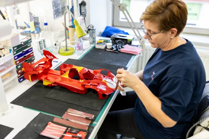 Az egyes makettmotorok összeszerelését számozott próbapéldányok segítik. A fenti képen egy Bugatti Chiron W16-os, négy turbófeltöltővel szerelt motorjának kicsinyített mása látható. A Le Mans-i versenyautók összes matricáját az eredeti pozícióba helyezik a maketteken is (lent) – Fotó: Bődey János / Telex