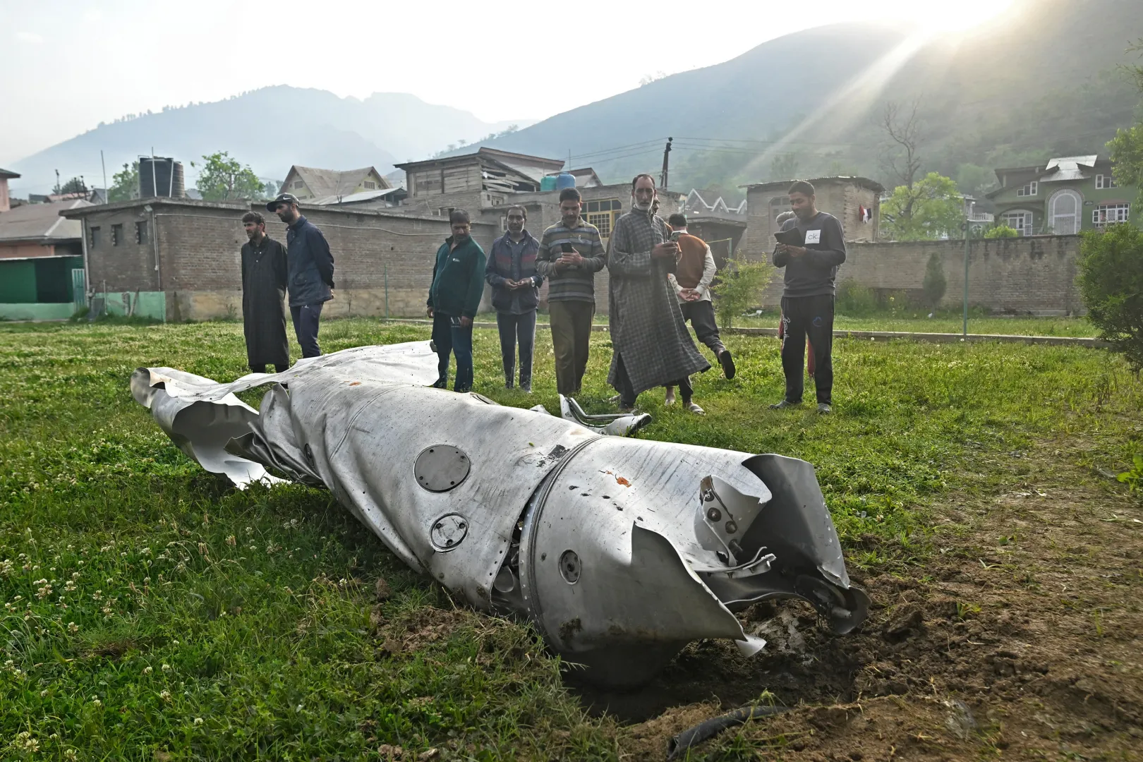 Helyi lakosok nézik a Szrinagarhoz közel Vujanban egy rakéta maradványait 2025. május 7-én. India és Pakisztán között majdnem teljeskörű háború tört ki a vitatott hovatartozású Kasmírban, de az amerikai kormány végül tárgyalóasztalhoz ültette a feleket – Fotó: Tauseef Mustafa / AFP