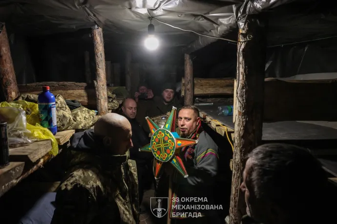 Katonai lelkész énekel együtt ukrán katonákkal 2025. december 25-én a donyecki régióban – Fotó: Volodymr Petrov / Az ukrán fegyveres erők 33. dandárjának sajtószolgálata / AFP