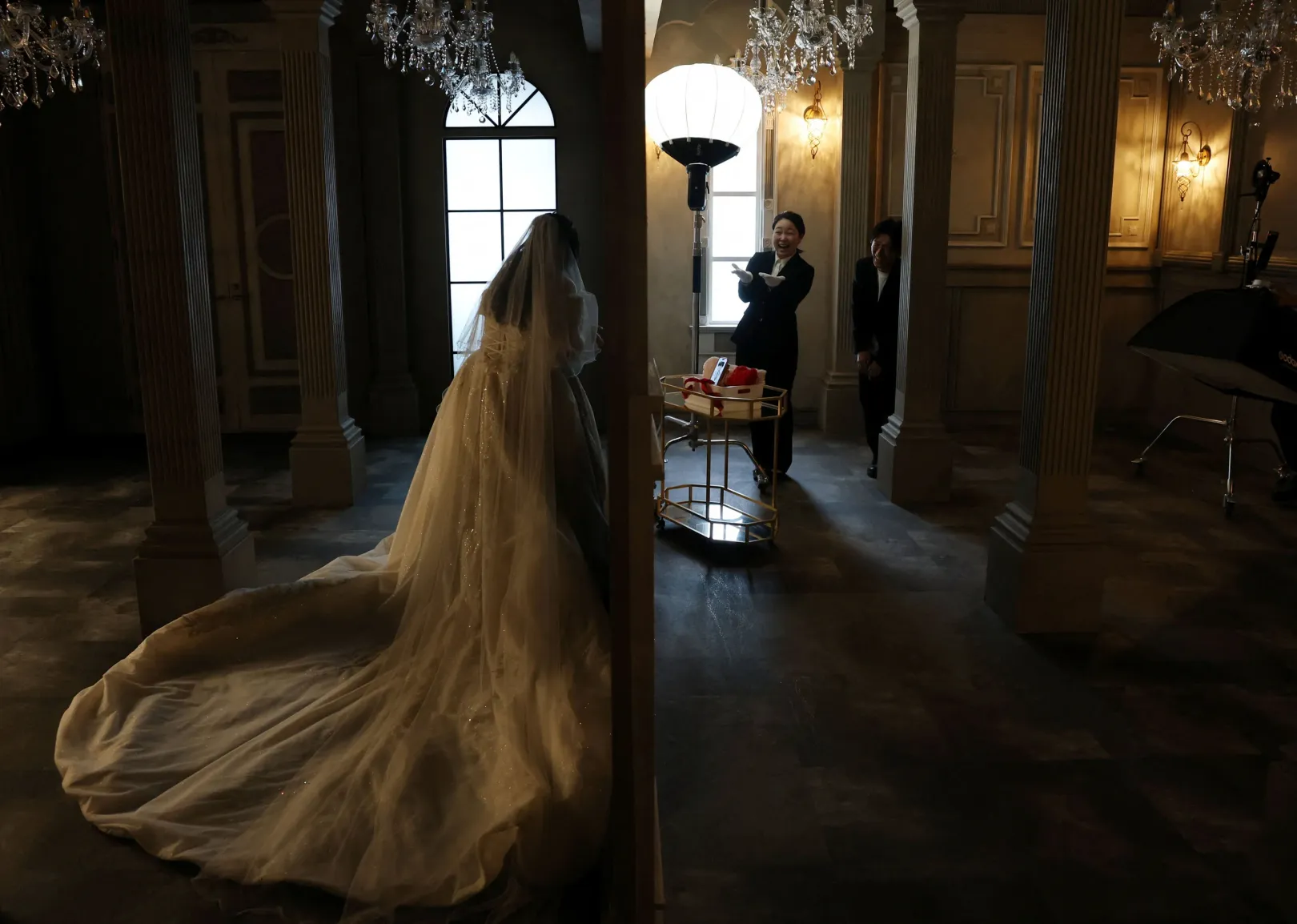 Ogaszavara Szajaka és Naoki köszöntik a menyasszonyi ruhába öltözött Nogucsit a szertartás előtt – Fotó: Kim Kyung-Hoon / Reuters