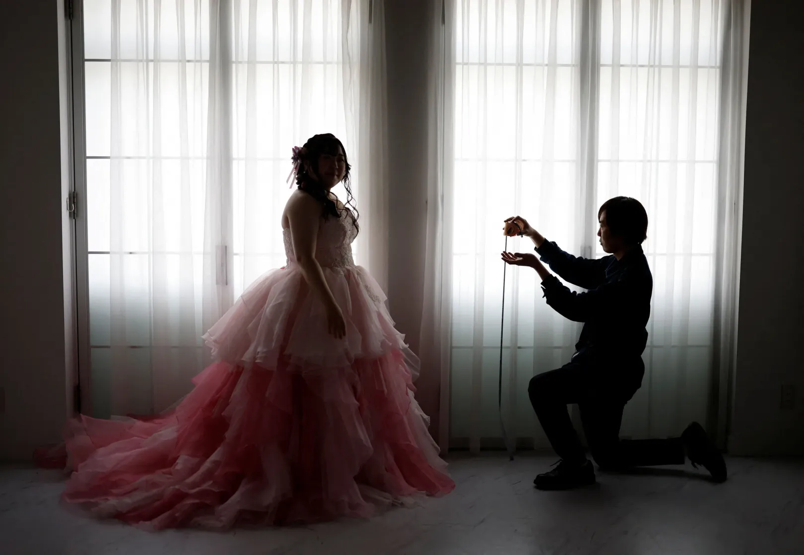 Az esküvői fotós méreteket vesz, hogy később élethű magassággal photoshopolhassa rá a képre Klaust – Fotó: Kim Kyung-Hoon / Reuters