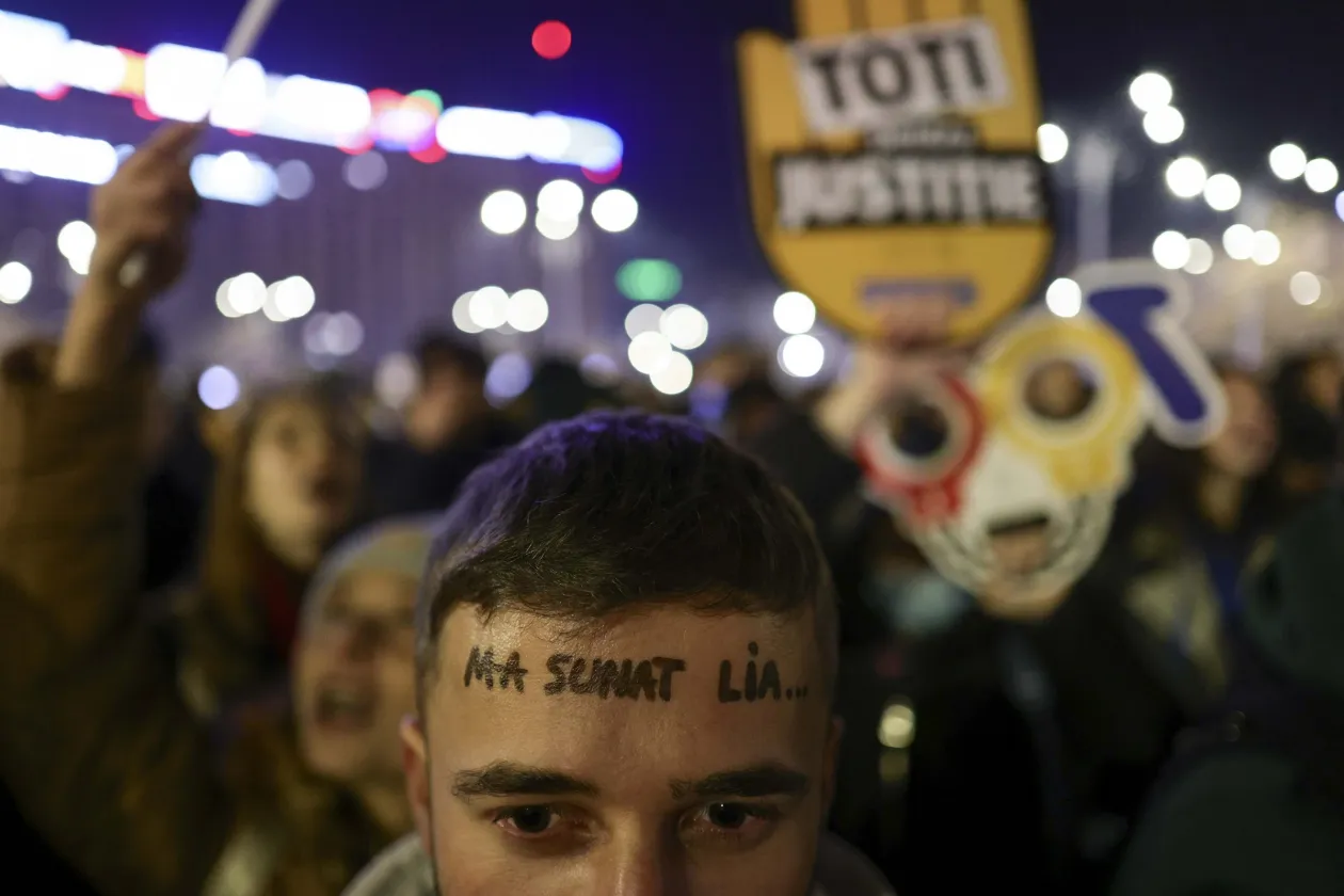 Első kép: "Biztosítom a korruptak védelmét" felirat olvasható egy Lia Savonea kartonfigura kezében. – Fotó: Codrin Unici / Inquam Photos. Második kép: "Hívott Lia..." mondat van felírva egy tüntető homlokára. – Fotó: Octav Ganea / Inquam Photos.