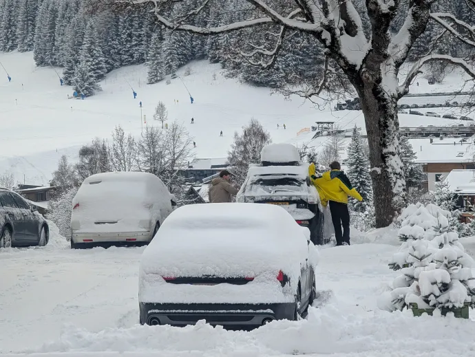 Turisták a behavazott autójukat tisztítják a tiroli Lermoosban – Fotó: Michael Nguyen / NurPhoto / AFP
