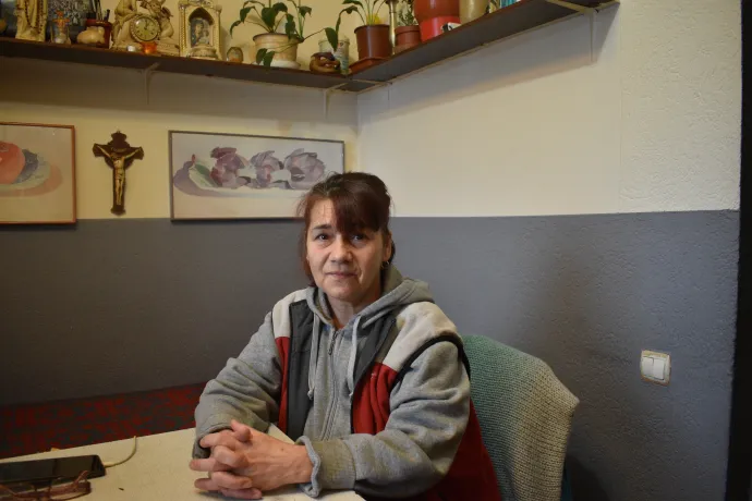 A szociális lakás B lépcsőházának bejárata és Hanzi Klára lépcsőházfelelős – Fotó: Tőkés Hunor / Transtelex