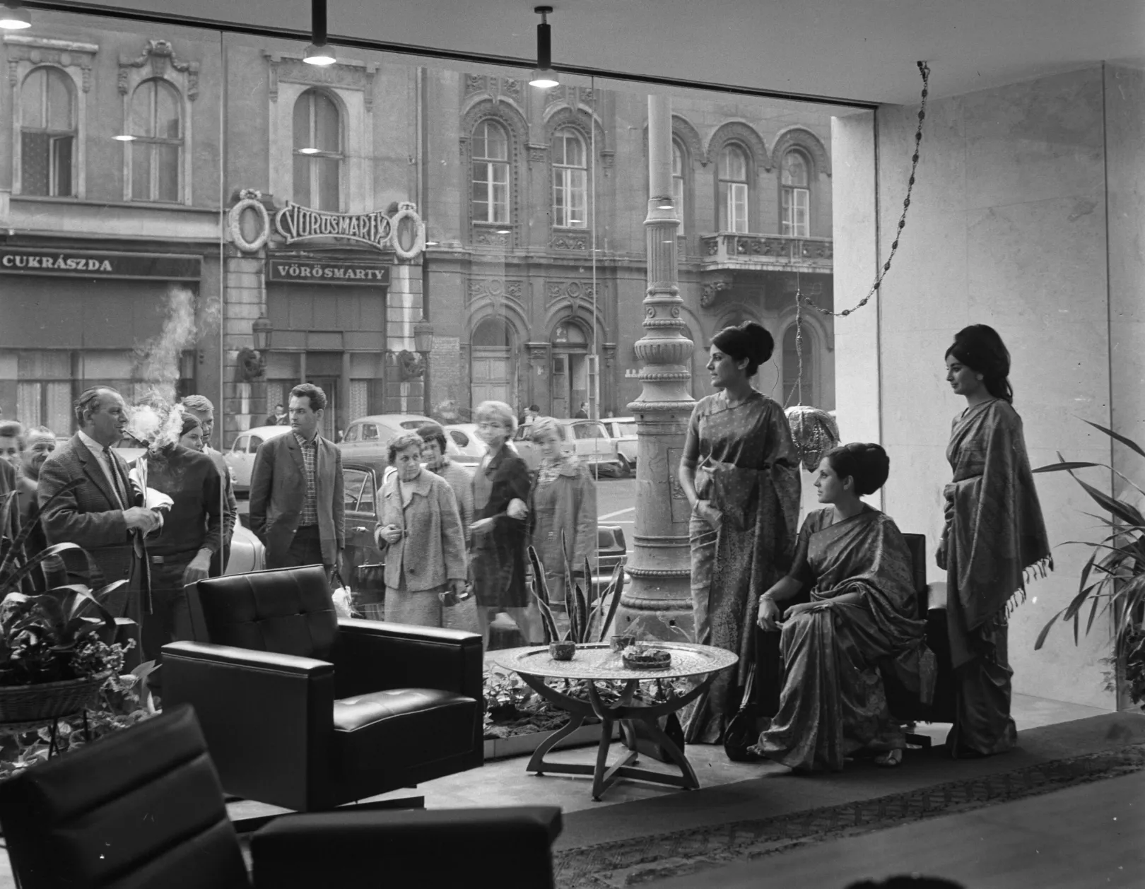 Az Air India légitársaság száriba öltözött légikísérői az újonnan megnyílt Vörösmarty téri irodában 1968. május 3-án. Az üvegen túl a Vörösmarty cukrászda látható – Fotó: Keleti Éva / MTVA