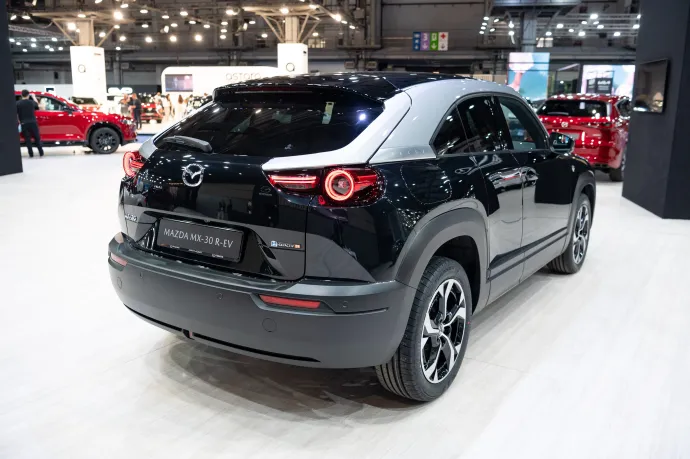 Mazda MX-30 R-EV a 2023-as barcelonai autószalonon és BMW i3 REx a töltőn a gyártó lipcsei üzeménél – Fotó: Adria Puig / Anadolu / AFP és Jan Woitas / dpa / AFP