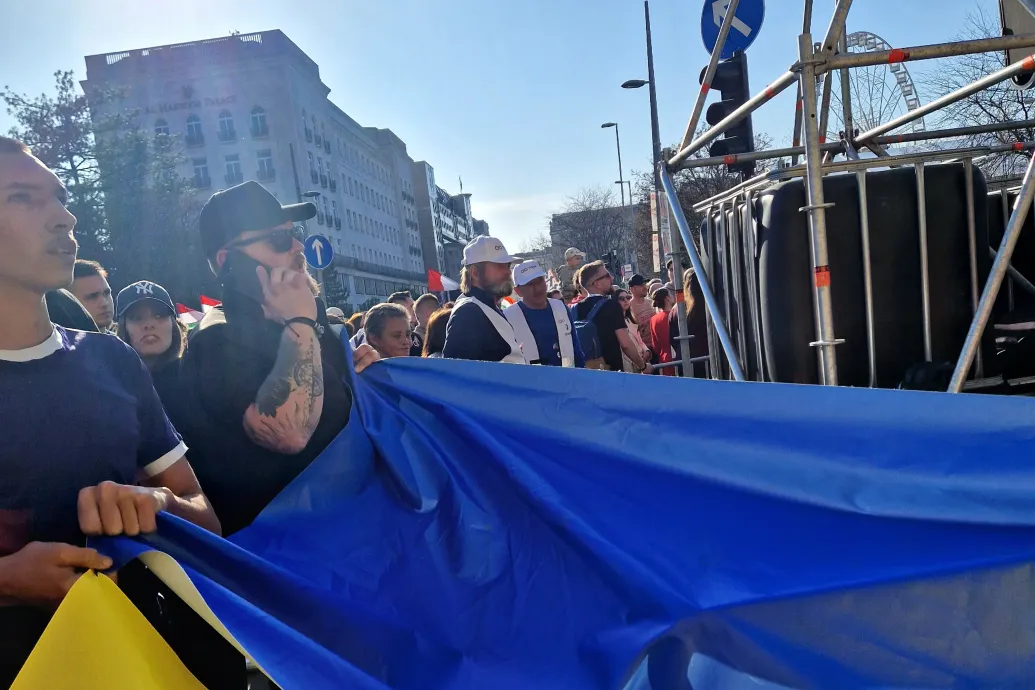 A Tisza felvonulásába ukrán zászlót becipelő csoport két tagját lefényképezték, ahogy az „ukrán háborús menetről” szóló molinót lógatják le egy házról