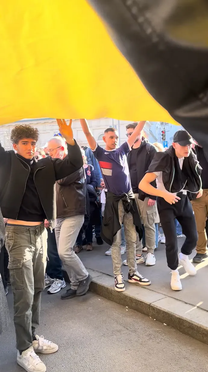 A két fiatal (jobb és bal szélen) az ukrán zászlóval a Nemzeti Meneten – Forrás: Telex.hu / YouTube