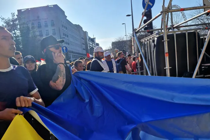 A Tisza felvonulásába ukrán zászlót becipelő csoport két tagját lefényképezték, ahogy az „ukrán háborús menetről” szóló molinót lógatják le egy házról