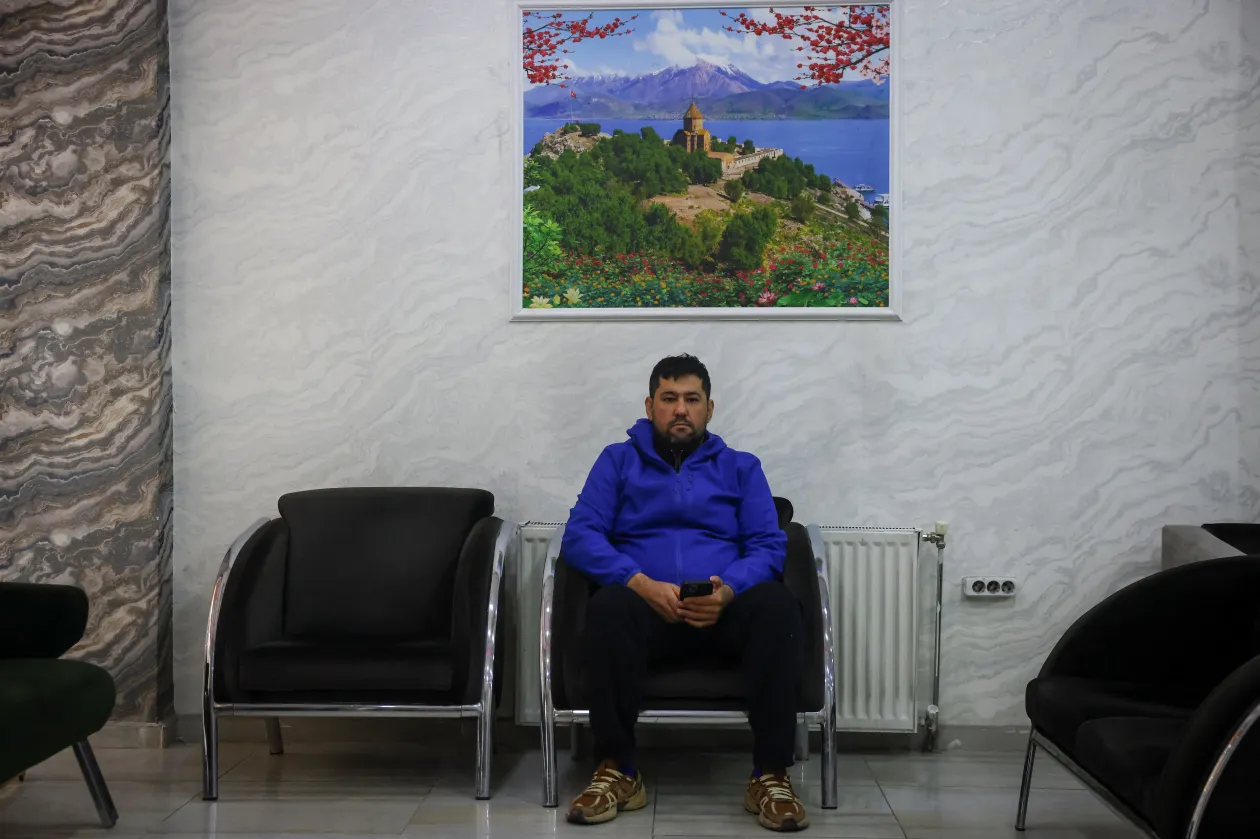 Hamid Sirmohammadzadeht a felesége várta a határnál. Jobbra a gyerekei képét mutatja – Fotó: Dilara Senkaya / Reuters