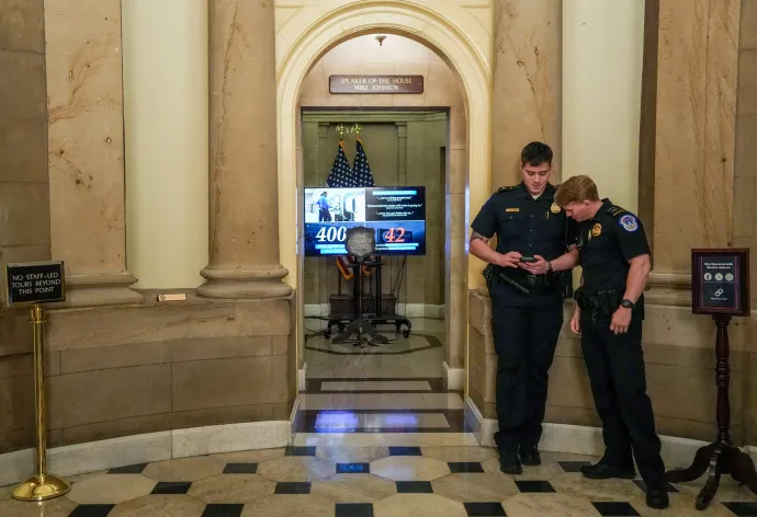 Az amerikai capitoliumi rendőrség tagjai Mike Johnson házelnök irodája előtt állnak, egy olyan képernyő mellett, amelyen a belbiztonsági minisztérium (DHS) finanszírozásával kapcsolatos információk jelennek meg, miközben a képviselőház szavaz a kormányzati leállás részleges megszüntetéséről a washingtoni Capitoliumban, 2026. március 27-én – Fotó: Leah Millis / Reuters