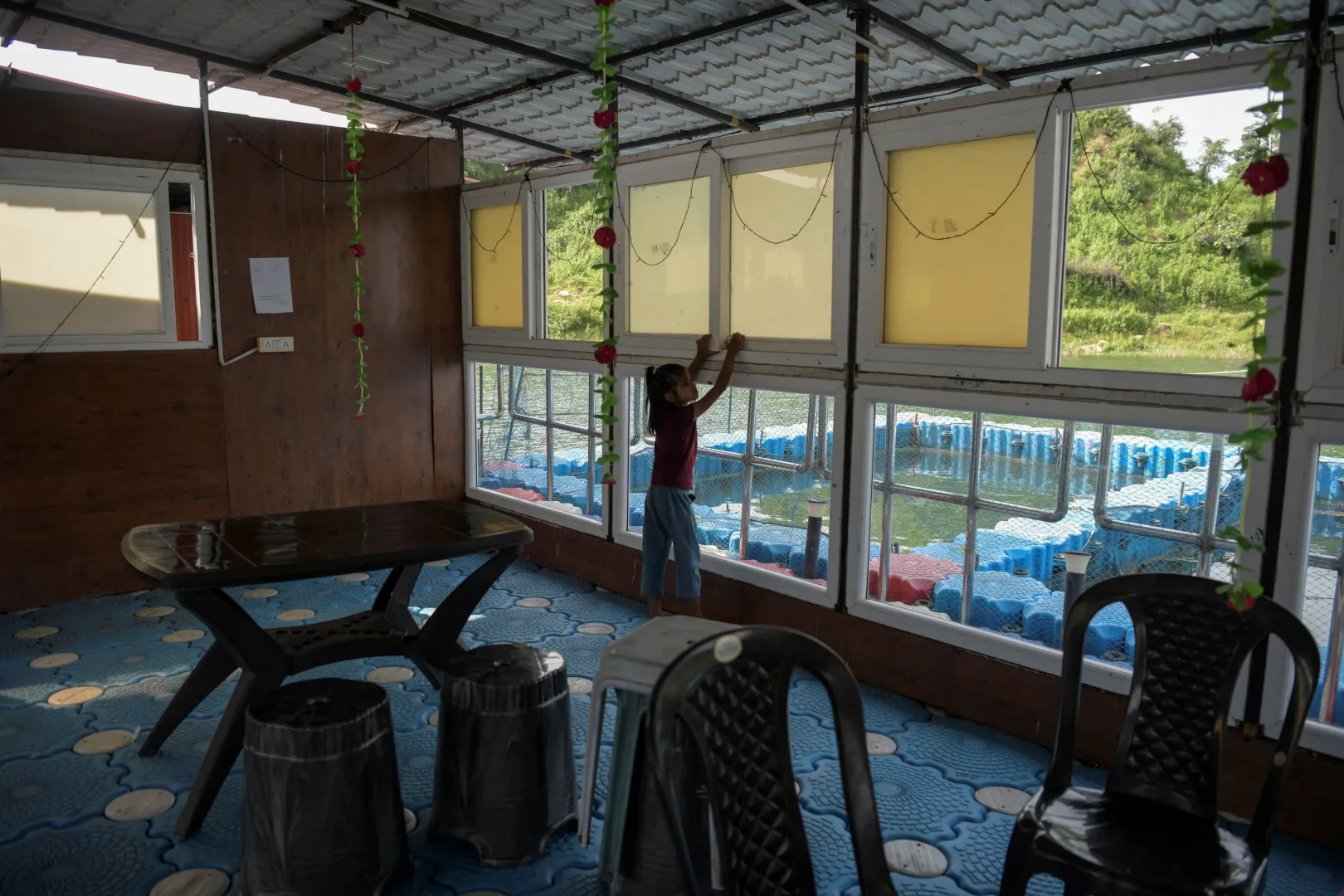 Bhumi Gupta, Savita Gupta lánya nyitja ki az úszó étterem egyik ablakát – Fotó: Avijit Ghosh / Reuters