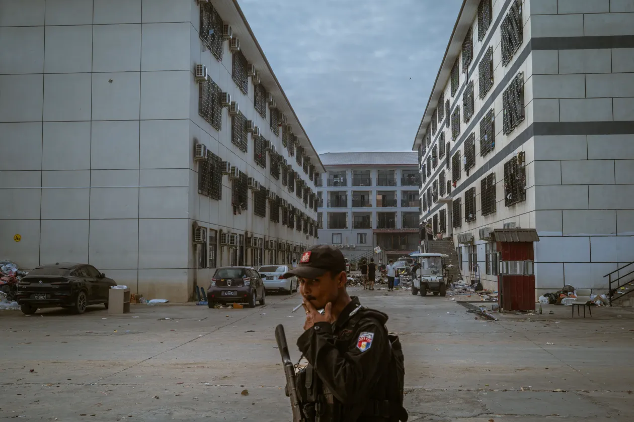 A Shunda Park irodái feldúlva maradtak, miután a mianmari hadsereg és a közeli ellenzéki milícia között fellángoltak a harcok. A komplexum egyes részei professzionális irodai környezetre emlékeztettek, más részeken viszont a dolgozók egy „sziszifuszi körforgásban” rekedtek, napi 12 órás műszakokkal. Min Let Pan, 2025. december 5.A Karen National Liberation Army egyik katonája járőrözik a Shunda Park területén. Körülbelül 900 kínai alkalmazott hetekig elbarikádozva maradt itt a rajtaütést követően, attól tartva, hogy hazatelepítésük azonnali letartóztatáshoz vezethet a kínai hatóságok részéről. Min Let Pan, 2025. december 5. – Fotó: Jes Aznar (Philippines, for The New York Times)