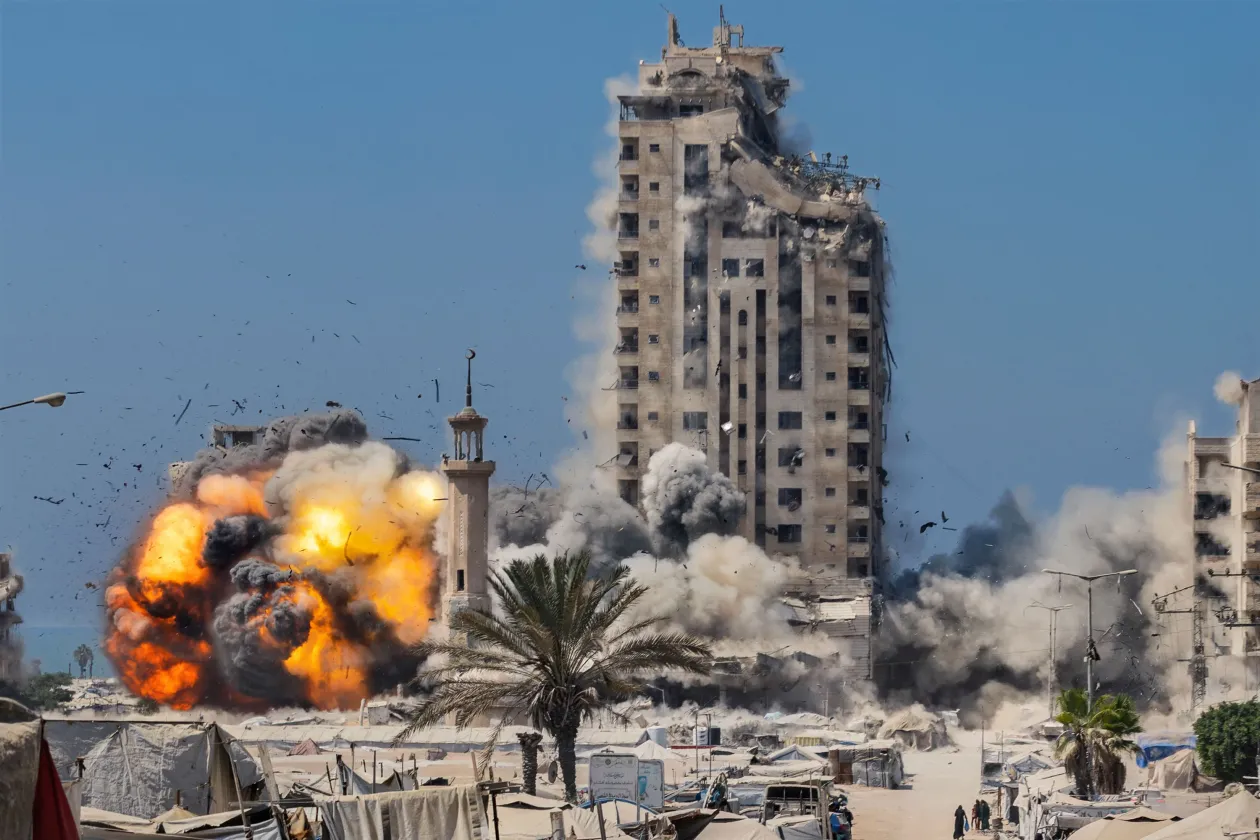 A Mustaha-torony összeomlik egy katonai csapás miatt az otthonukat elhagyni kényszerült palesztinoknak menedéket nyújtó sátrak százai között, miközben Izrael fokozta a Gázaváros elleni katonai offenzívát. Gázai övezet, 2025. szeptember 5. / Tamer Hasszan al-Safei és családja megtöri a ramadáni böjtöt otthonuk romjai között. Az élelmiszerhiány miatt a szokásos bőséges asztal helyett csak alapvető ételeket szolgáltak fel. Beit Lahia, Gázai övezet, 2025. március 4. – Fotó: Saher Alghorra (Palestine, for The New York Times)