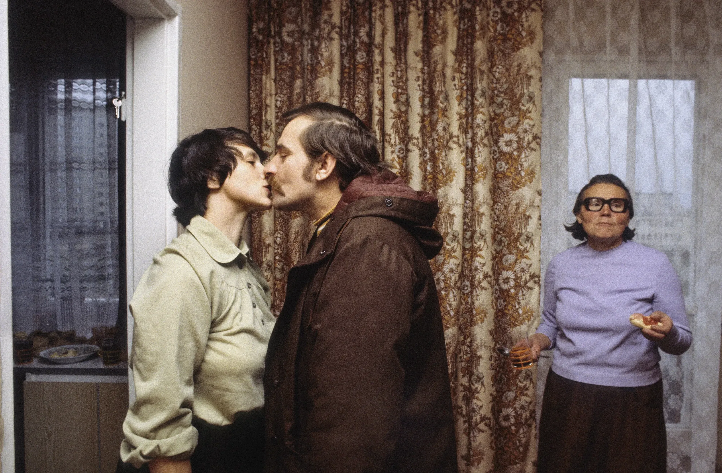 Gdańsk, 1980 novembere, Lech Wałęsa búcsúzik feleségétől, Danutától, mielőtt dolgozni indul a Szolidaritás Független Szakszervezet wrzeszczi irodájába. Jobbra Danuta Wałęsa édesanyja, Feliksa Gołoś – Fotó: Chris Niedenthal