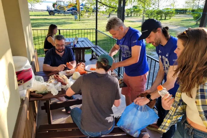 Fent: Cseke Balázs és Fehér János futóink a váltásuk előtt – Fotó: Molnár Zoltán / Telex; Lent: Közben a táborban csapattagok előkészítik a vacsorát – Fotó: Iván András / Telex