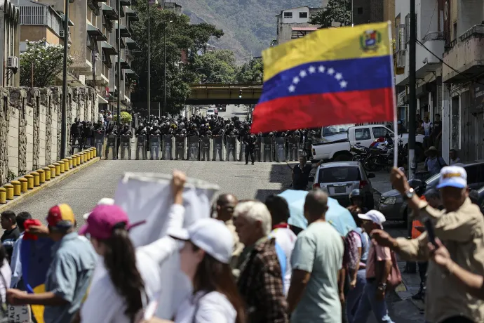 Munkások vonulnak el a rohamrendőrség sorfala előtt egy tüntetésen, Caracasban, 2026. április 9-én – Fotó: Jesus Vargas / Getty Images