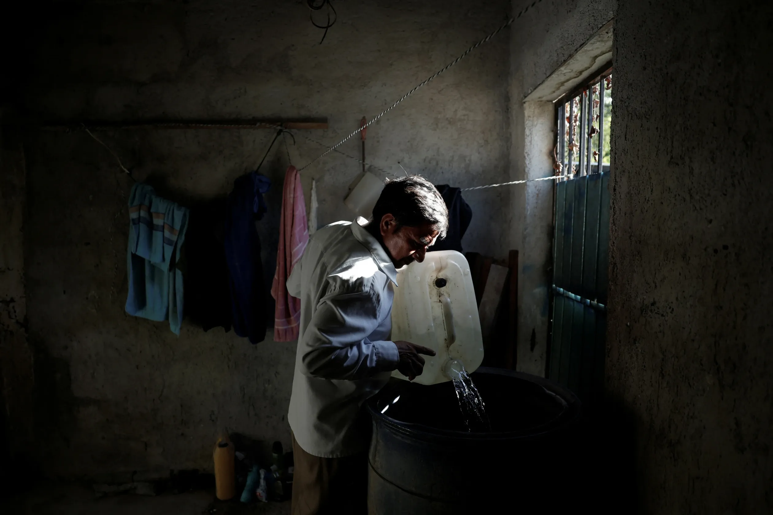 Nicolas Moreno Jimenez másik településről hozott ivóvizet tölt át hordókba az otthonában Xpujilban, Campeche államban, 2025. november 12-én – Fotó: Daniel Becerril / Reuters