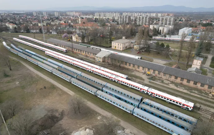 Tucatjával állnak a fővizsgára váró MÁV-os személykocsik a Dunakeszi Járműjavító telephelyén 2023. március 22-én. A háttérben a fehér személykocsik az egyiptomi vasutak számára készült járművek – Fotó: Máthé Zoltán MTI / MTVA