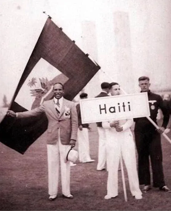 A haiti súlyemelő, René A. Ambroise Haiti címerrel kipreparált zászlajával az 1936-os nyári olimpiai játékok megnyitóünnepsége előtt – Forrás: Wikimedia Commons